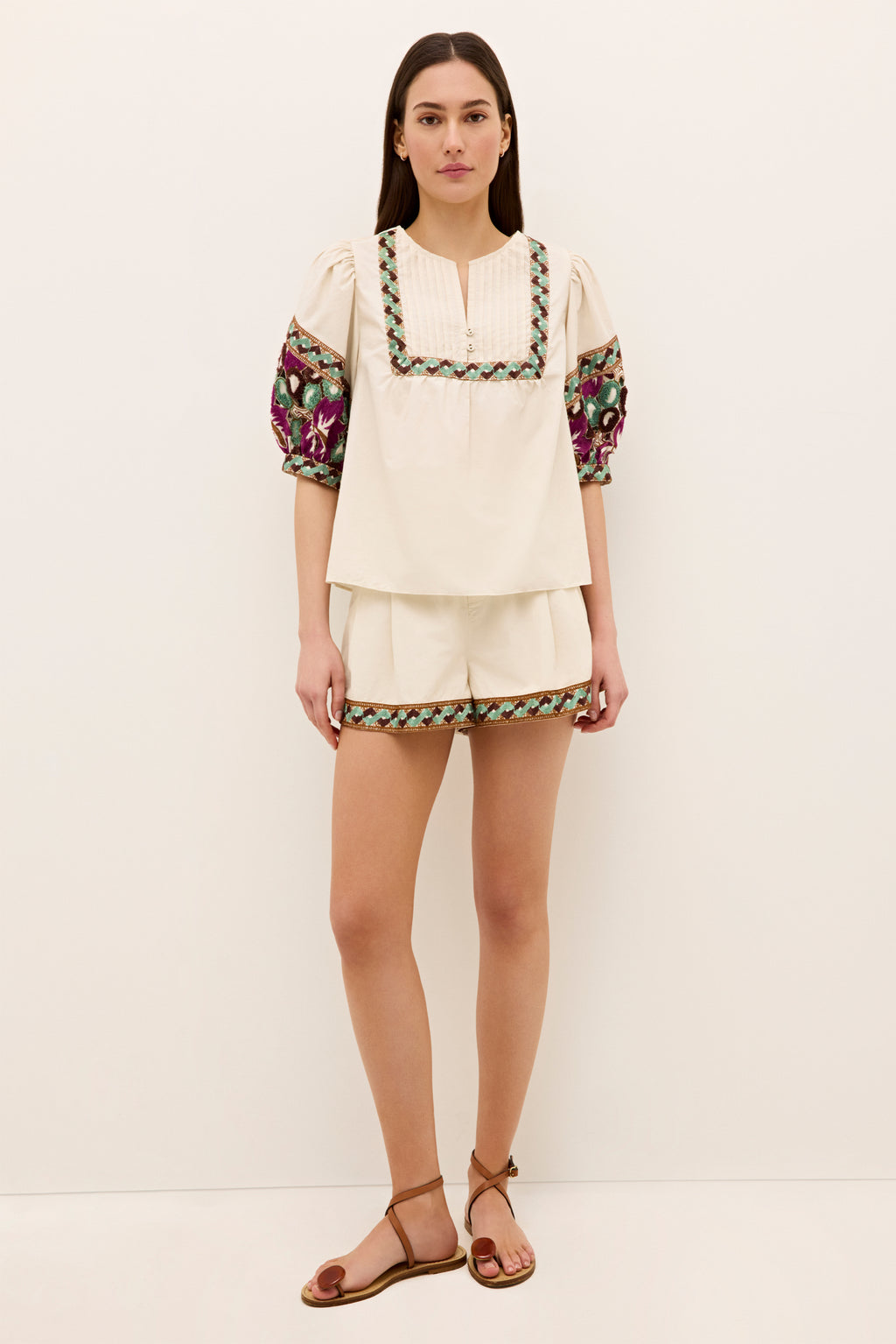 Cream top with split neckline and colorful embroidered sleeves