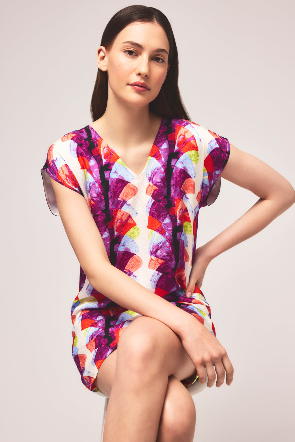 Sleeveless mini dress with bold geometric fan print in purples, pinks, and reds