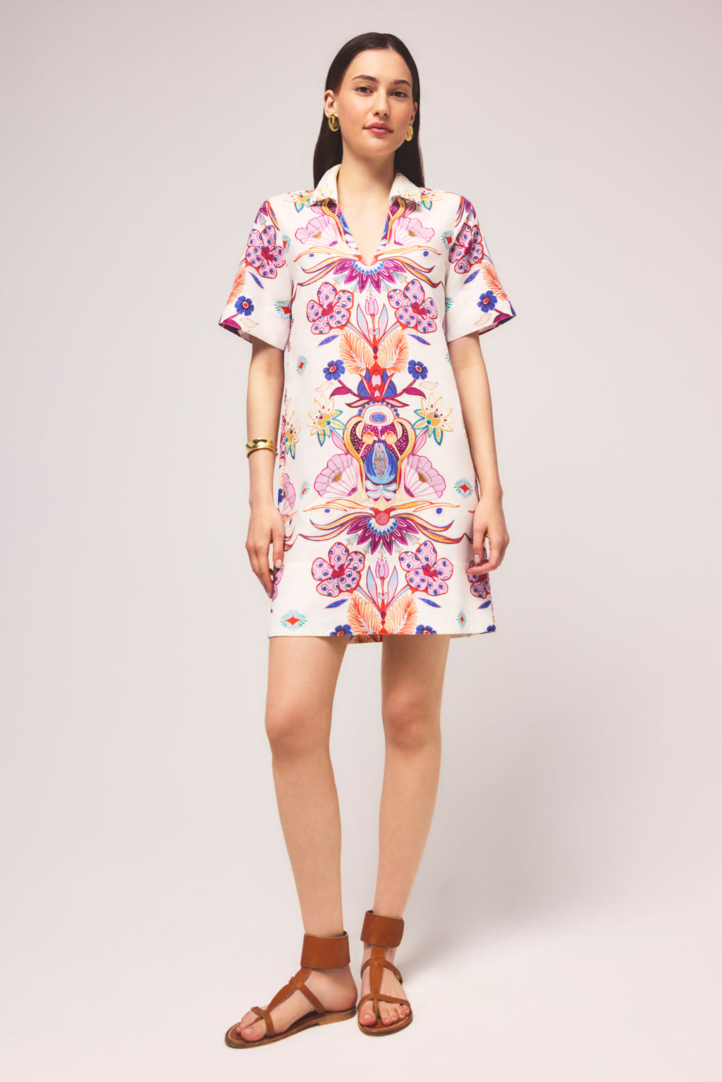 Short sleeved shirt dress with a vibrant floral and abstract motif on a white background