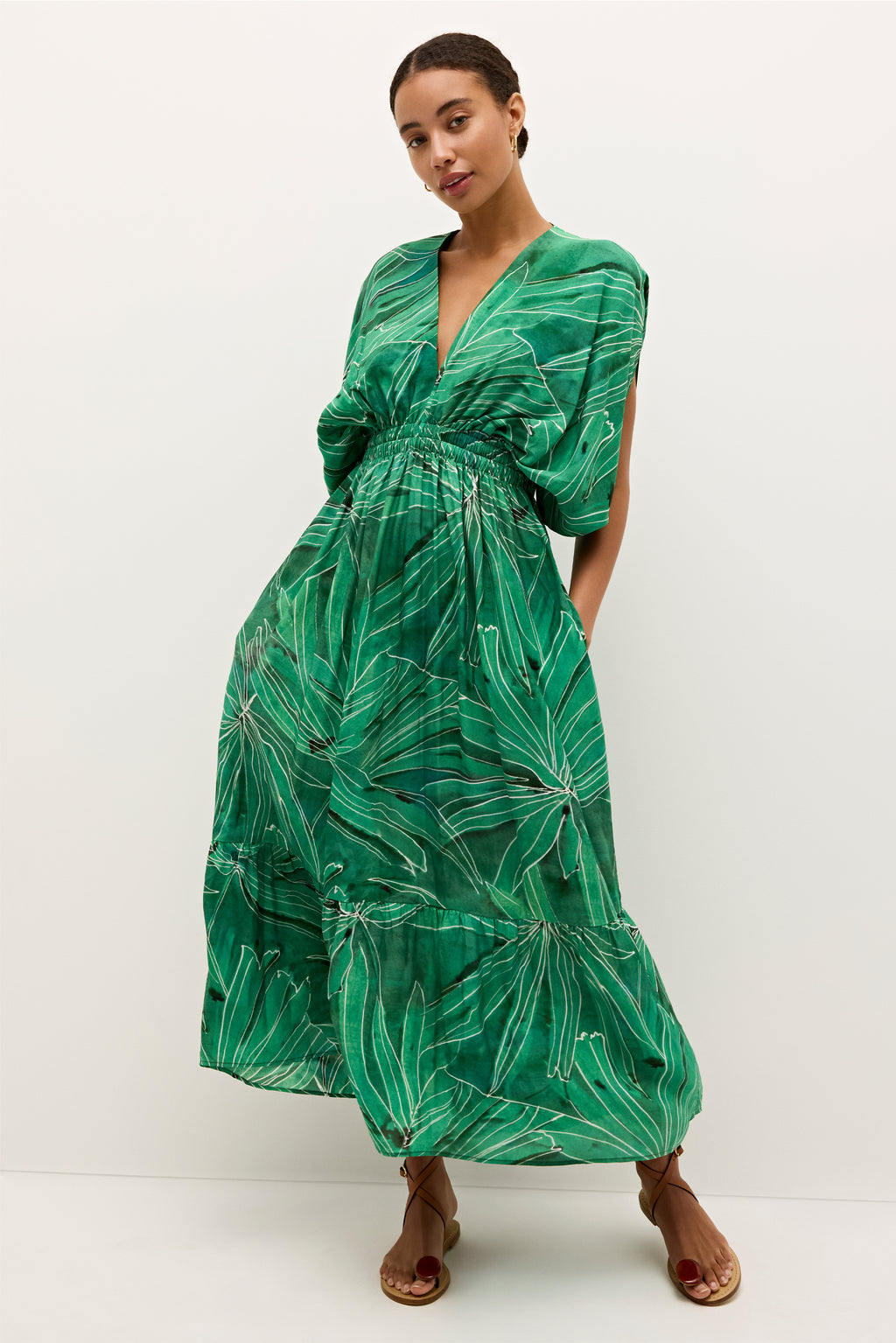 Flowy green dress with oversized leaf pattern and structured waistline