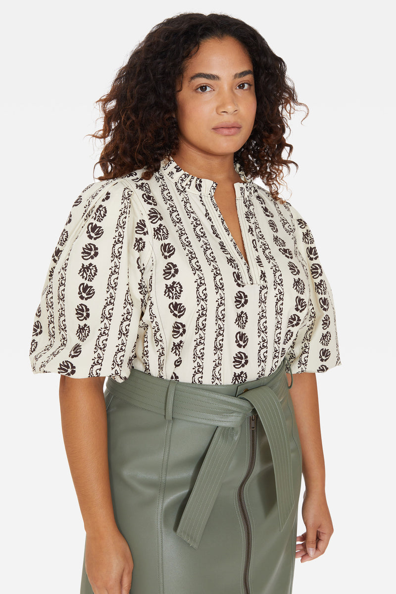 Cream color top with statement three-quarter length sleeve, and black vertical floral print that mimics embroidery 