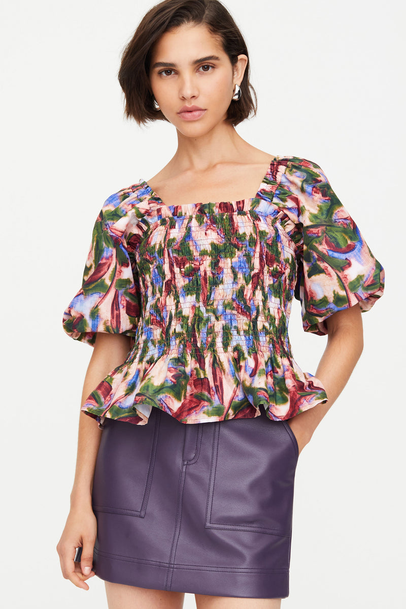 Short puff sleeve top with a smocked bodice and peplum-like flare in an abstract floral print