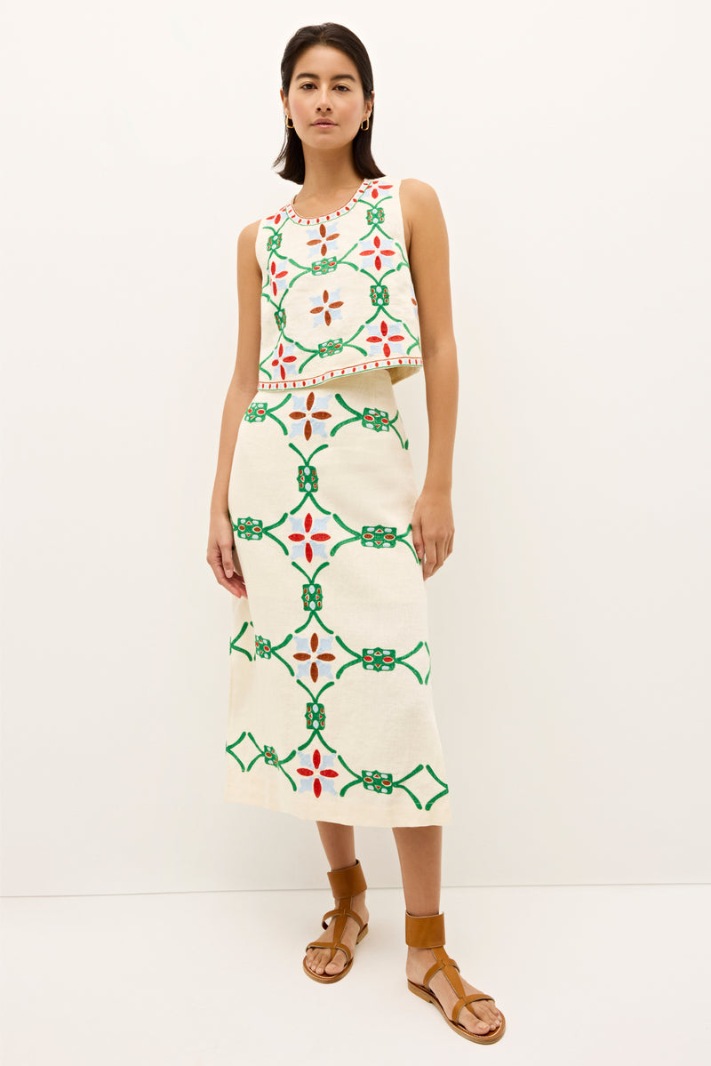 Embroidered cream top featuring symmetrical green, red, and blue motifs