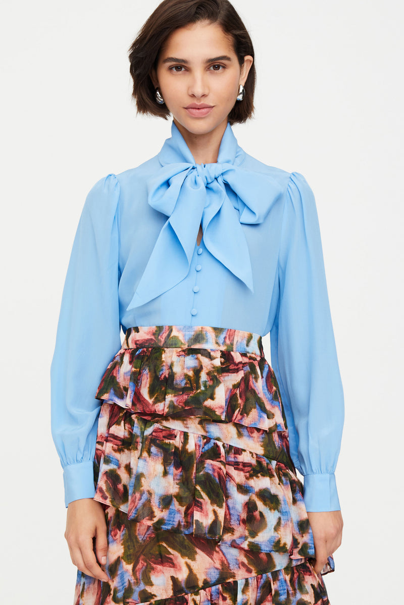 Blue blouse with large bow tied at the neck