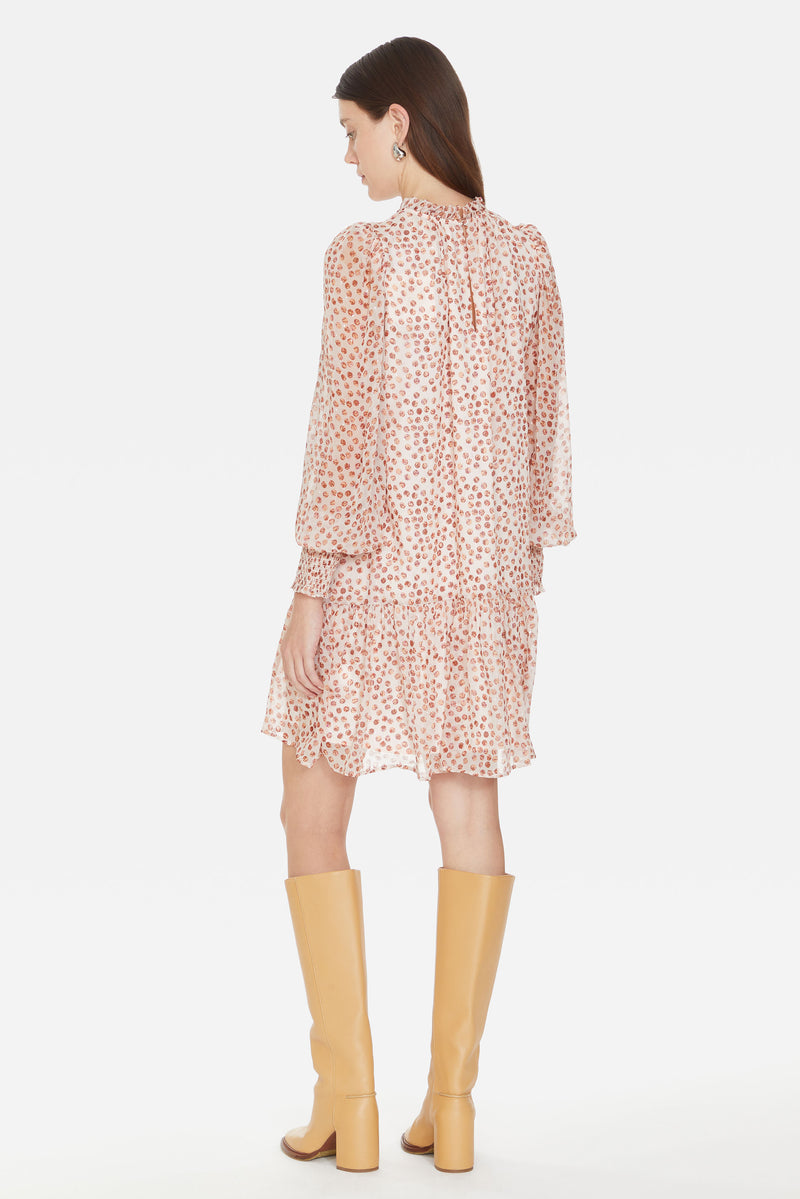 A-line dress with a lined bodice, metallic pink dot printed overlay, long smocked cuff sleeves, and a high ruffle neckline 