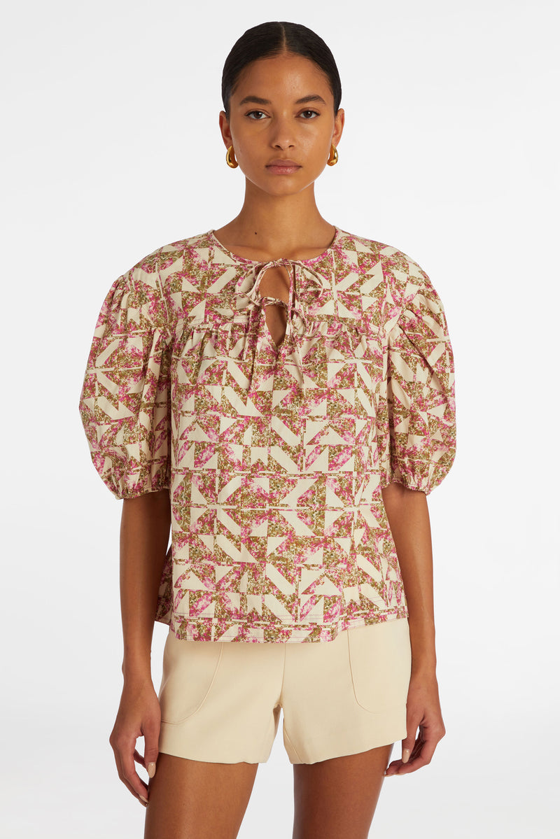 Pink and white kaleidoscope print top with short puff sleeves and a straight silhouette
