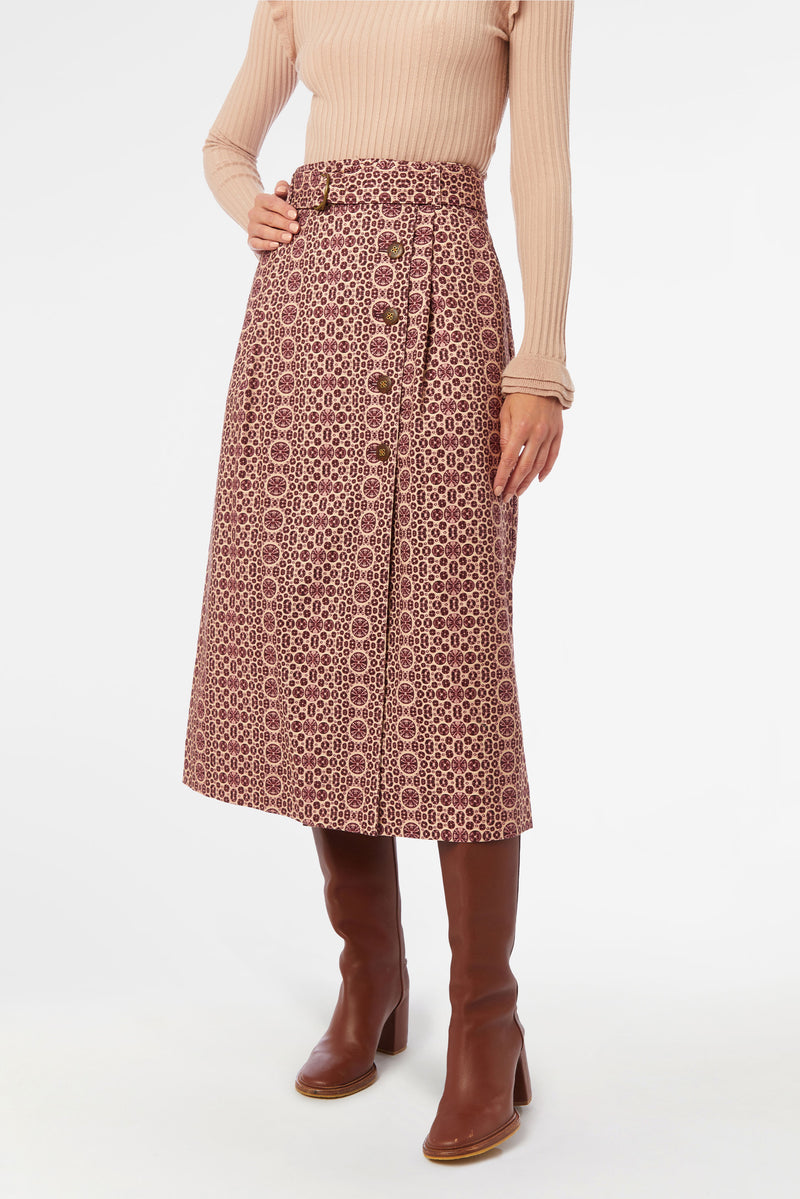 Belted column skirt with pockets and topstitch details in a deep red and tan geometric pattern