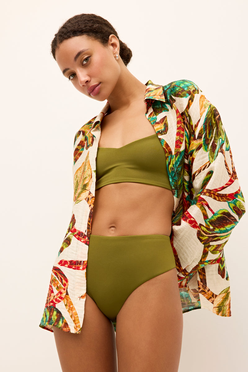 Long sleeve collared shirt with bold green, red, and teal botanical design 