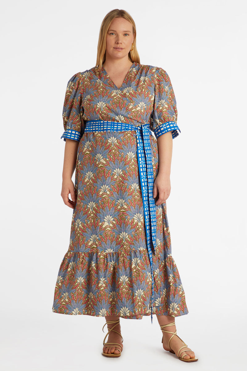 Maxi dress in a blue and red floral print with a blue and white checkered belt at the waist