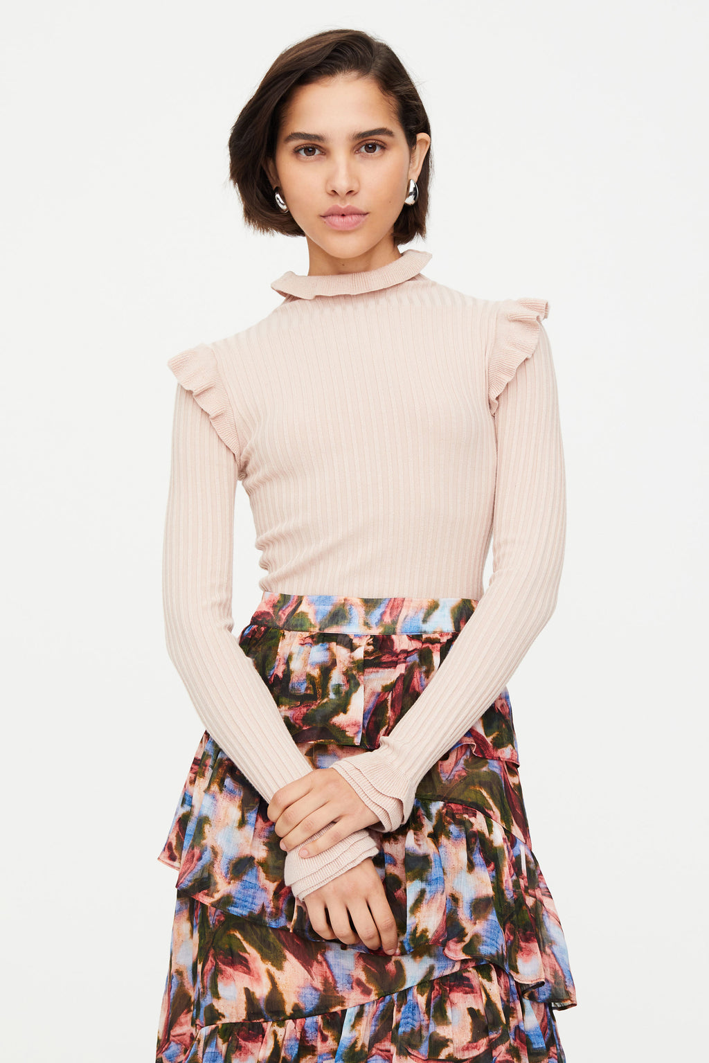 Pink ribbed turtleneck with ruffles on the shoulders and neck