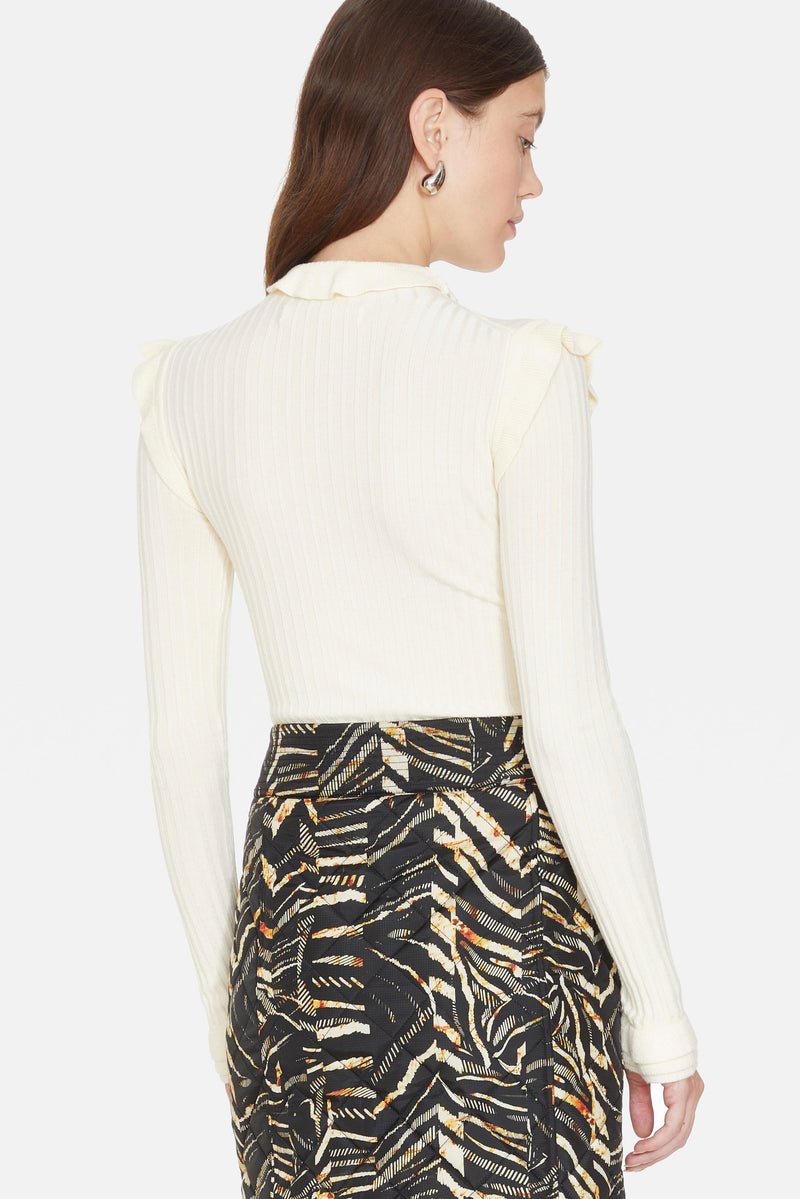 Off-white ribbed turtleneck with ruffle detailing on the shoulder, wrist, and collar