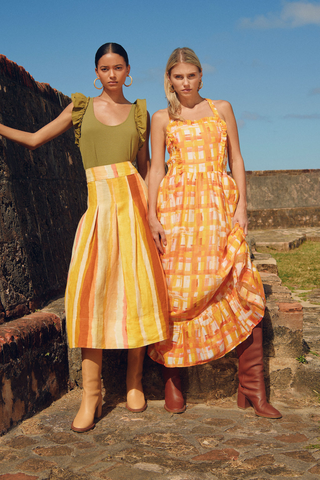 Orange and yellow checkered printed sleeveless dress that has a square neckline and is cinched at the waist