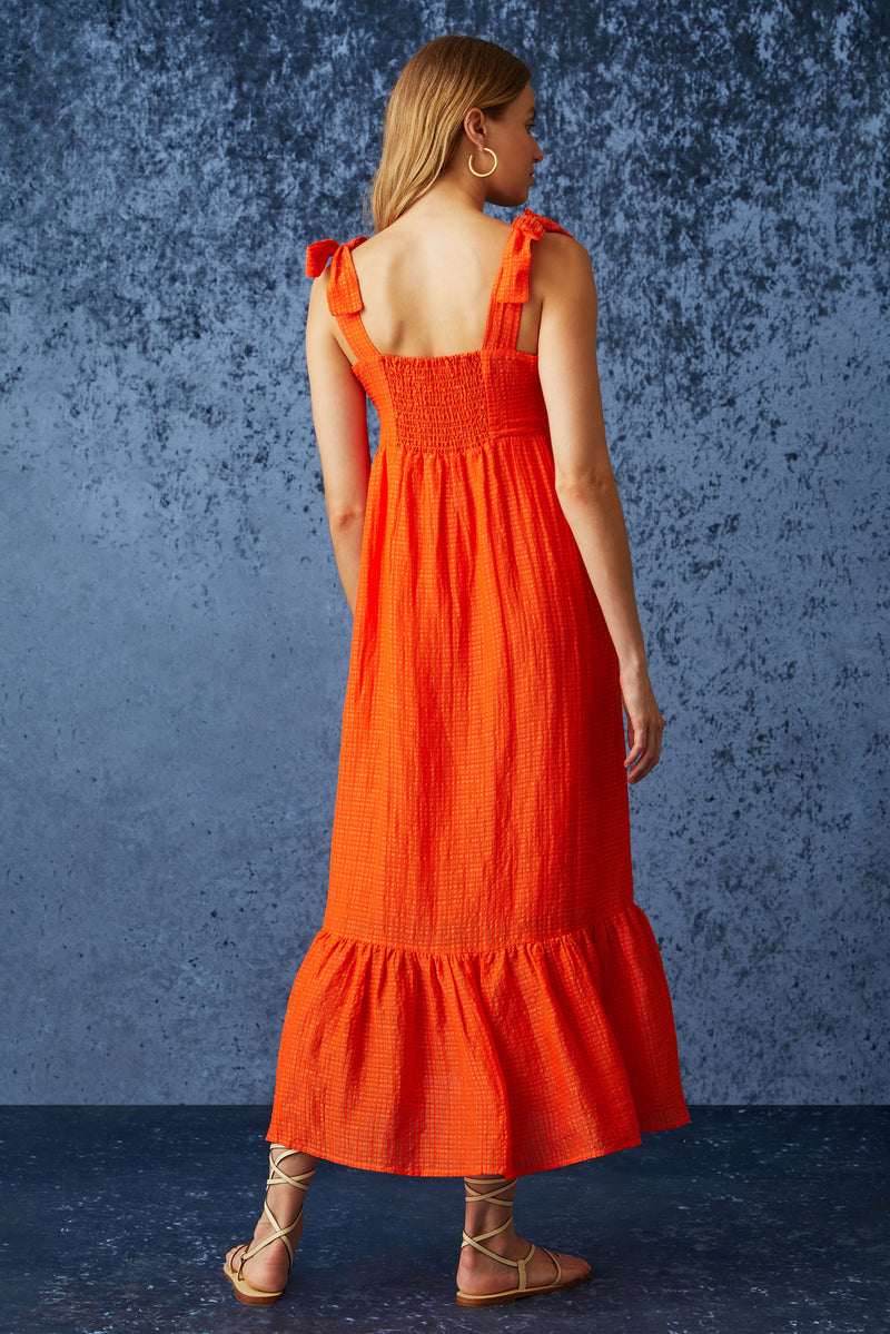 Flowy maxi dress with thick straps that tie at the shoulder in a bright orange solid color