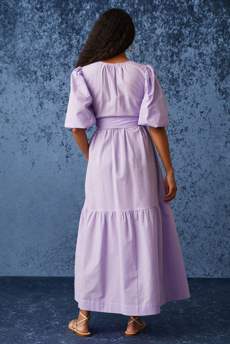 Long dress with v-neckline that is belted at the waist 