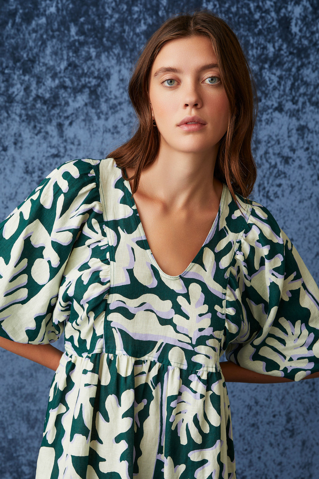 Midi dress with a v-neckline and short bubble sleeves in a dark and light green geometric floral print
