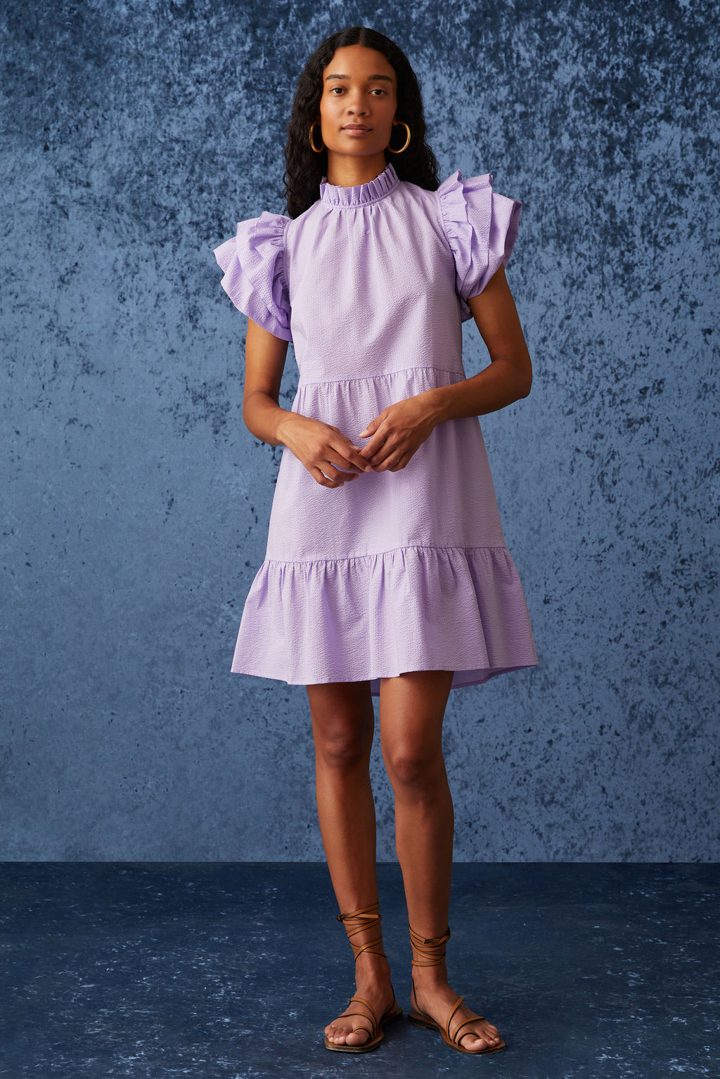 Short dress with short tiered ruffle sleeves and a high ruffled neckline in a light purple