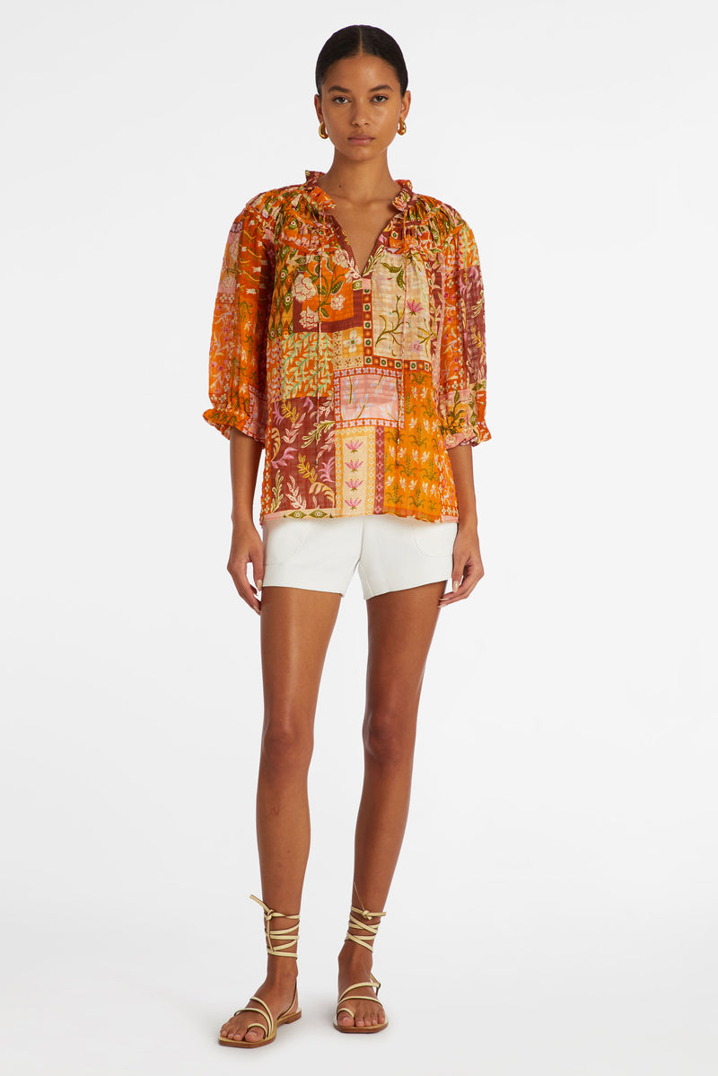 Orange floral patchwork top with elbow length sleeves and a v-neckline