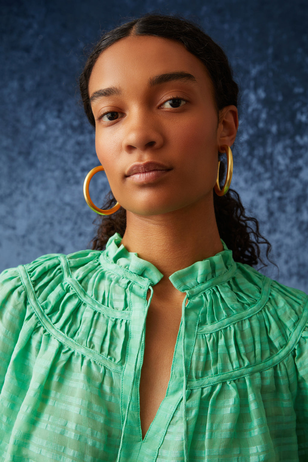 Bright green solid blouse with elbow length sleeves and ruffled cuff at the end of the sleeve