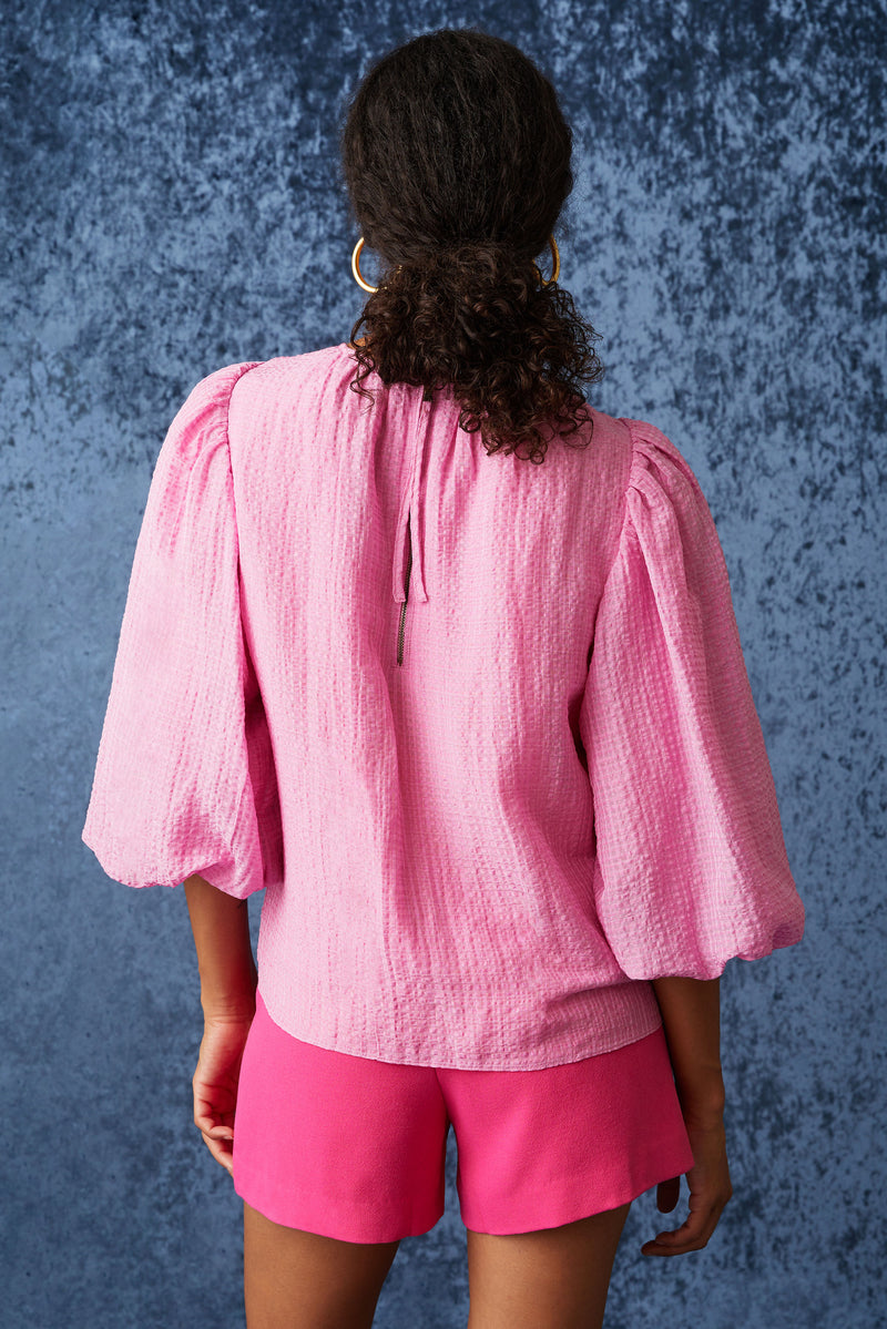 Solid pink top with three quarter paper bag sleeves