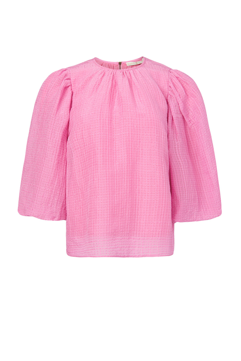 Solid pink top with full paper bag sleeves and a zipper at the back of the neckline