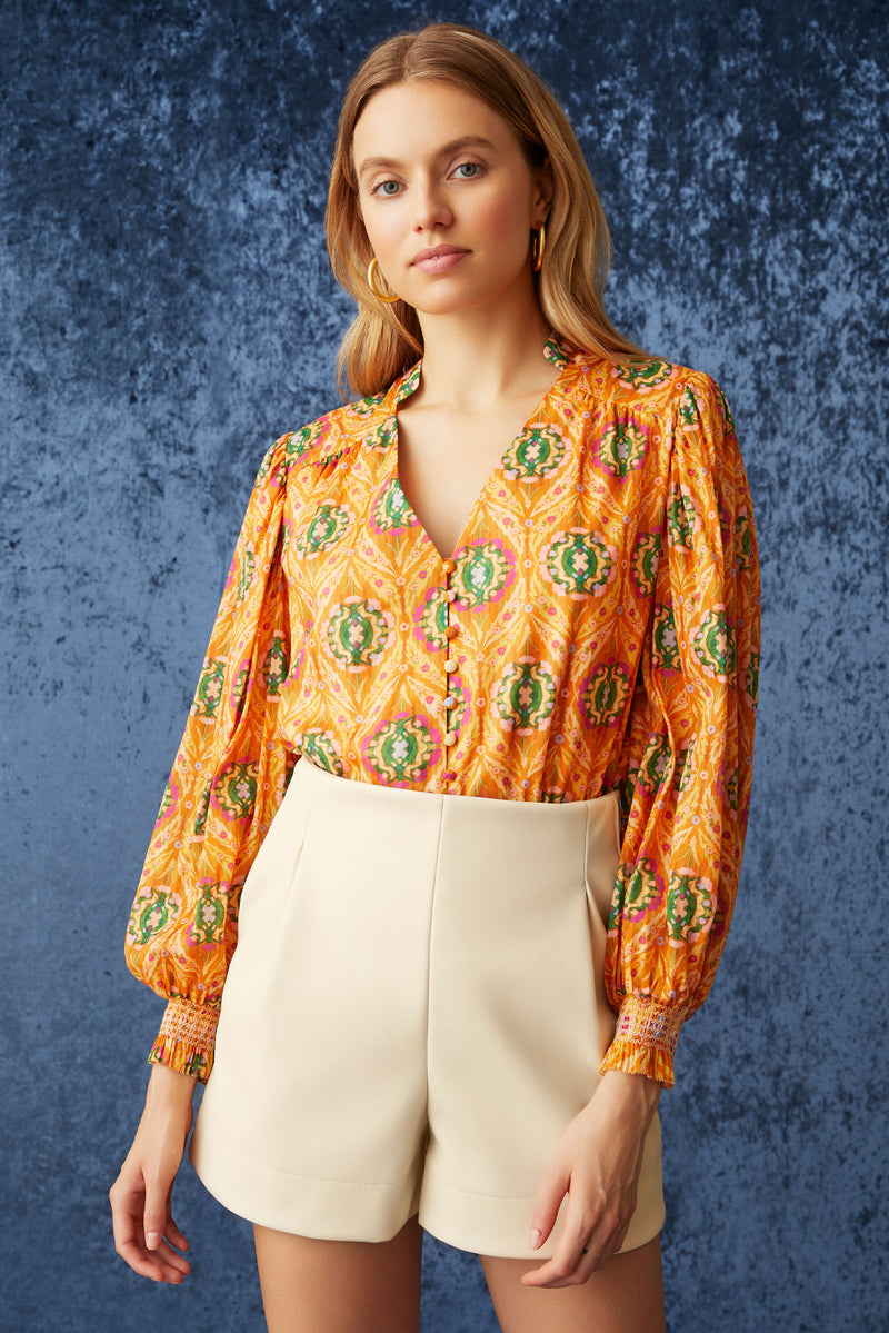 Long sleeve blouse with v-neck and straight silhouette in an orange circular print