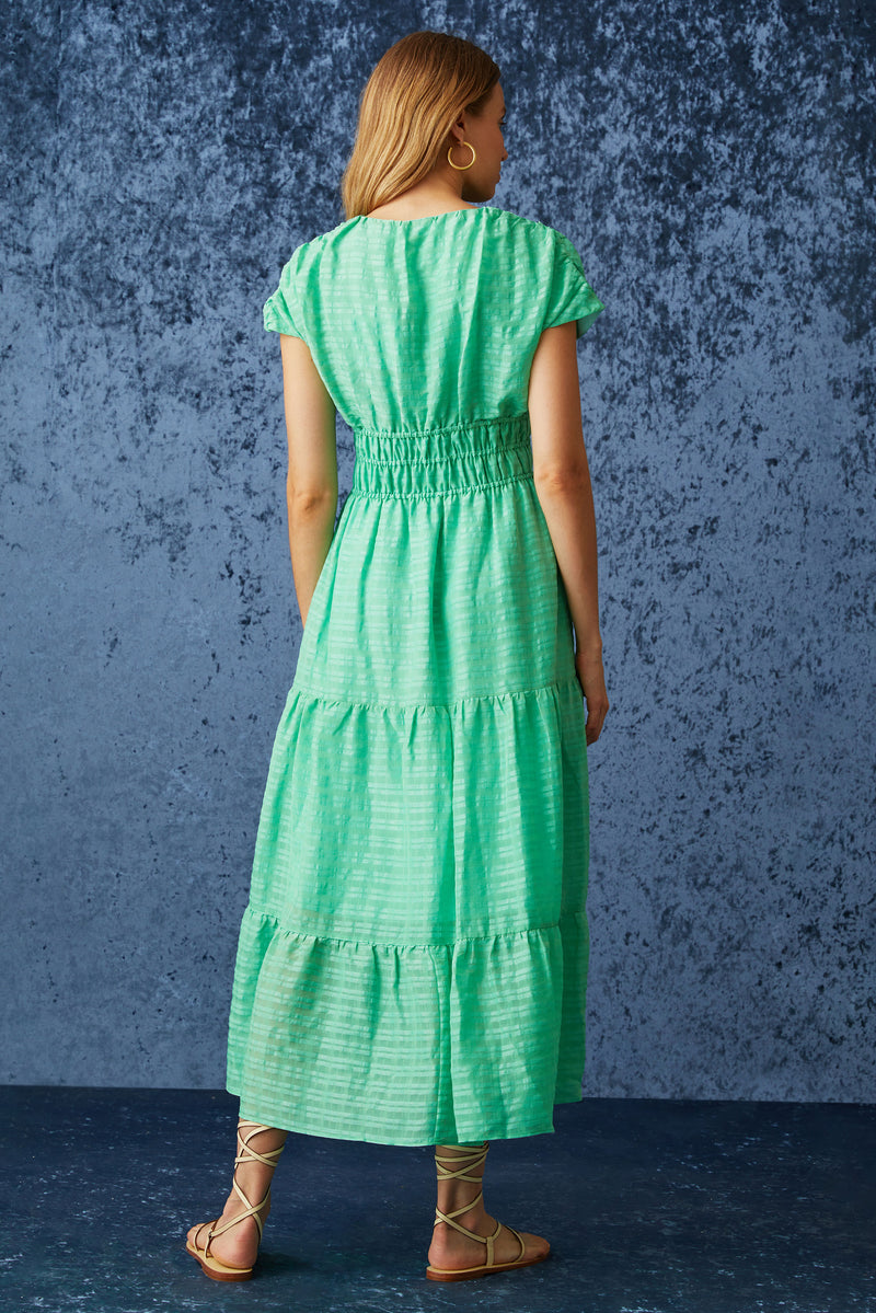 Bright green maxi dress with a v-neckline and a thick waistband that can be adjusted using a tie