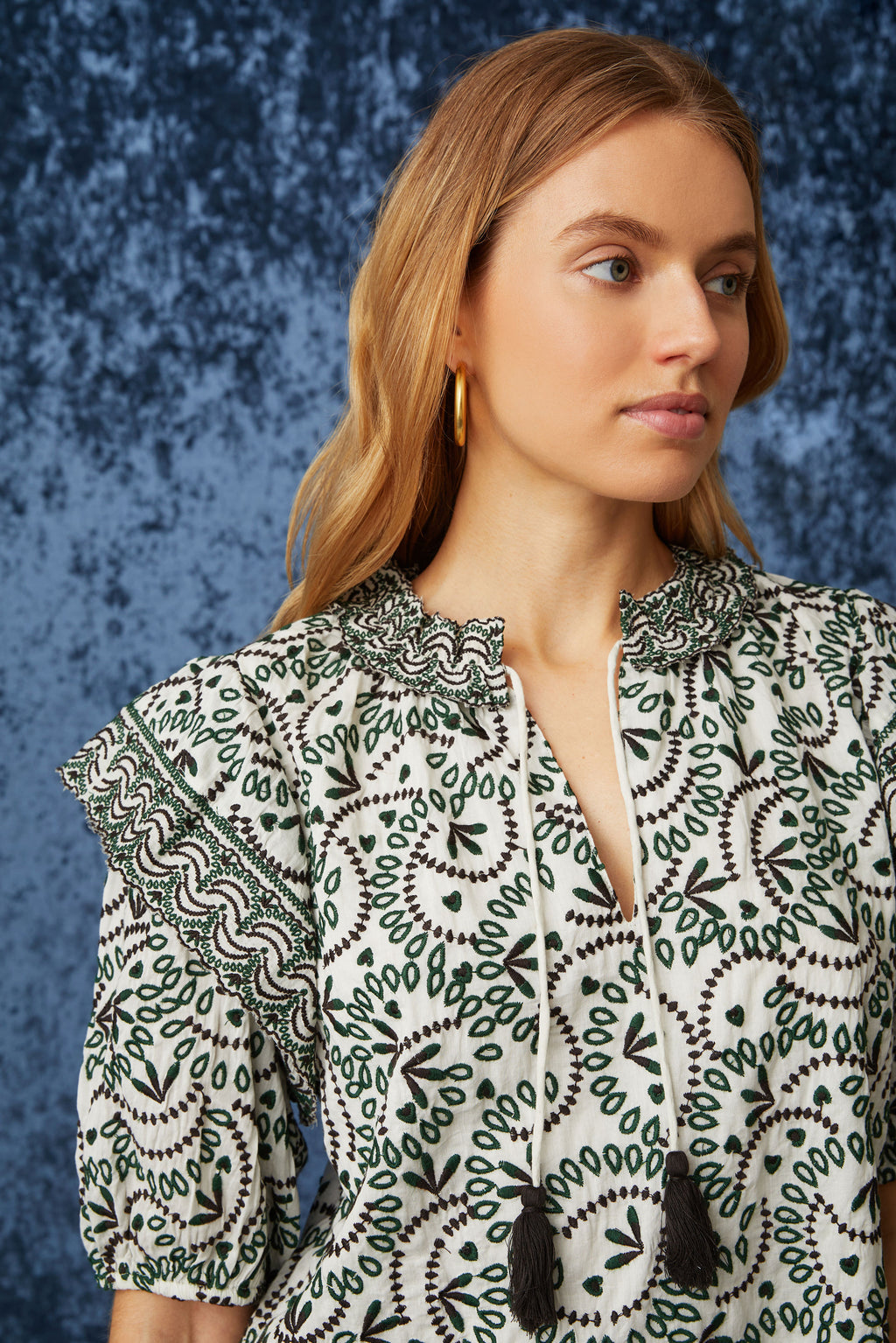 Top with v-neck and tie closure and tassels at the ends in a green and white floral embroidery 