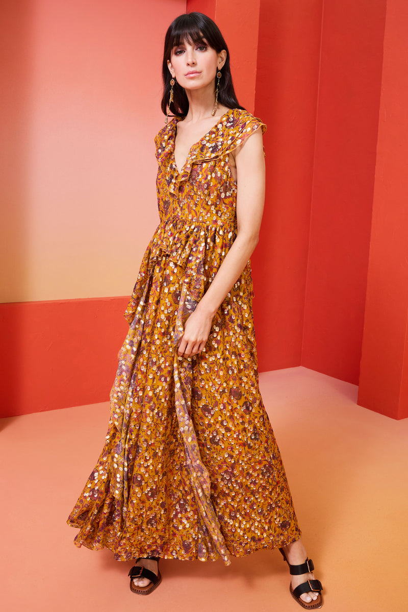 Long dress in a harvest floral print with gold detailing  cinched in at the waist with a ruffled waistline and v-Neckline