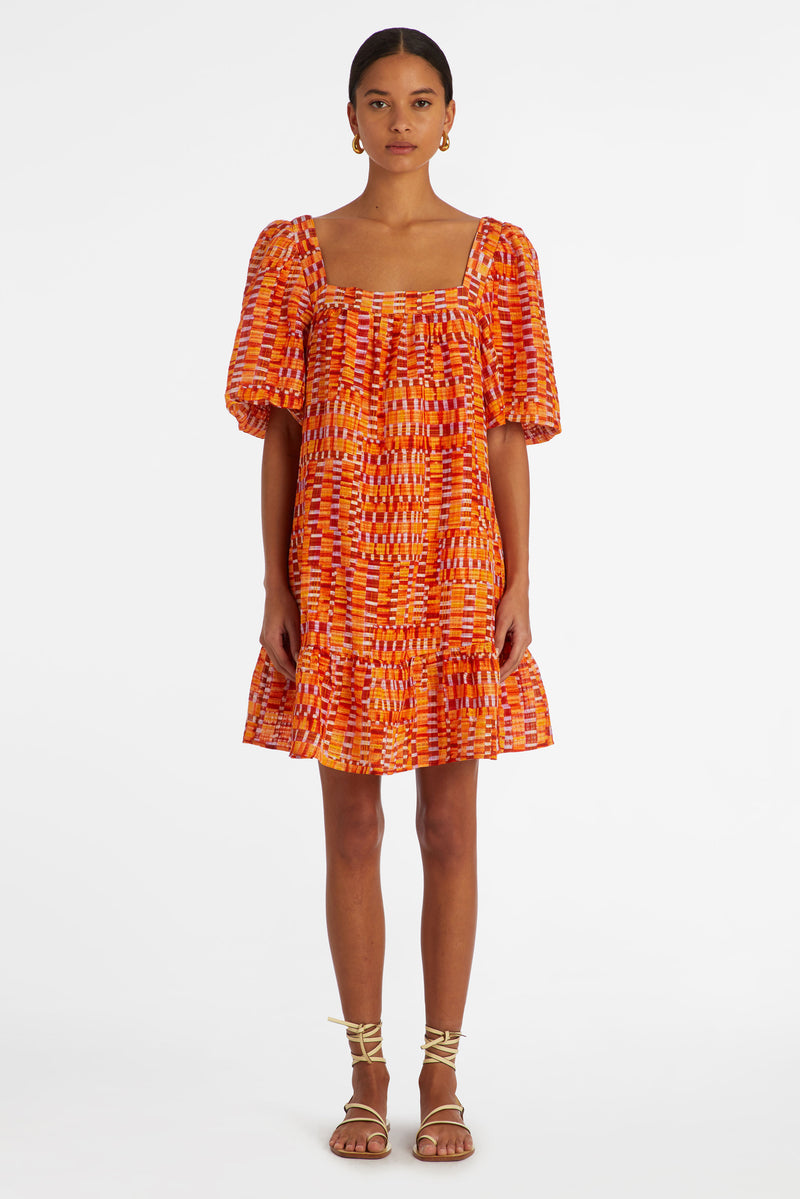 short dress with a slip on silhouette with a square neckline in an orange and red checkered print