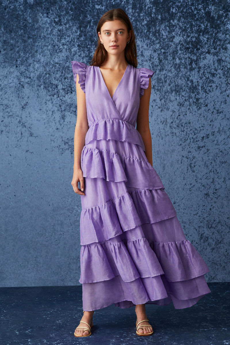 Sleeveless maxi dress with ruffled shoulder that is cinched at the waist and has asymmetrical tiered ruffles