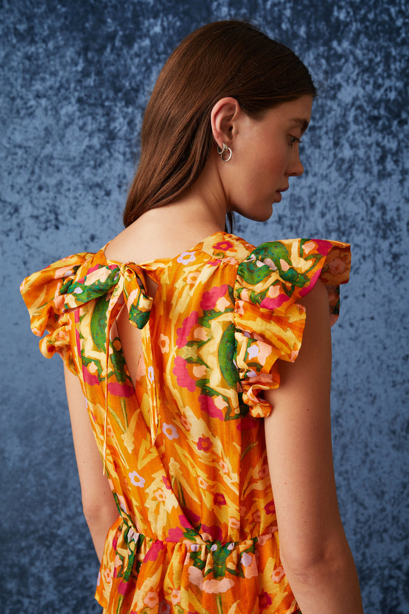 Orange circular geometric maxi dress with an asymmetrical tiered skirt