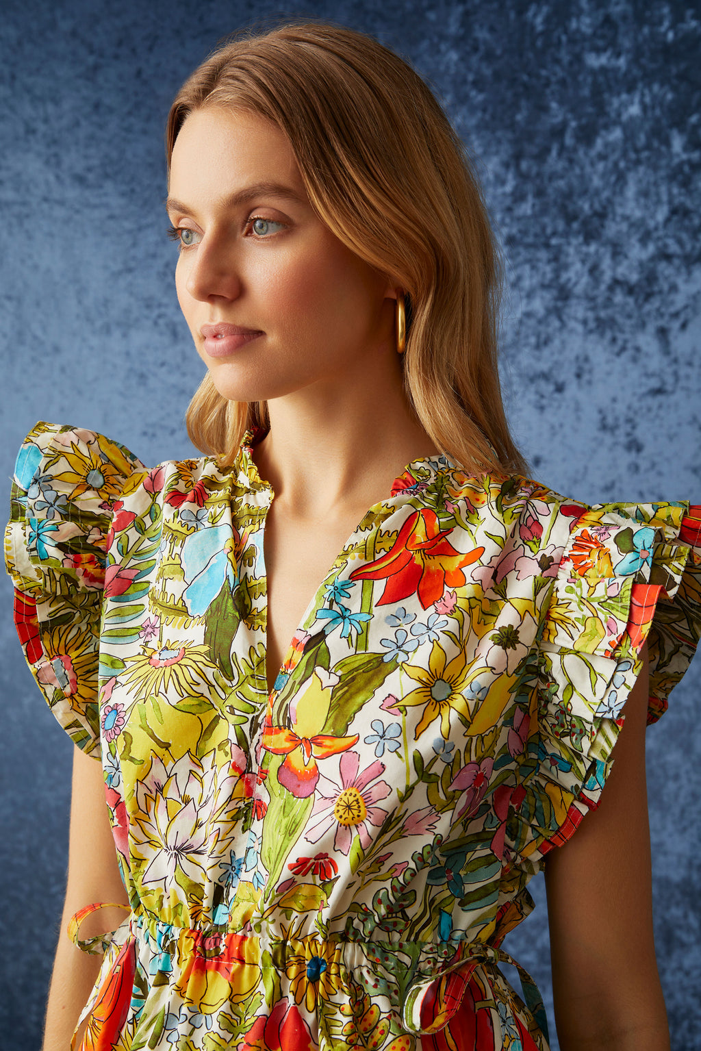 Multicolor floral printed top that has adjustable ties at each side of the waist to cinch in the waist