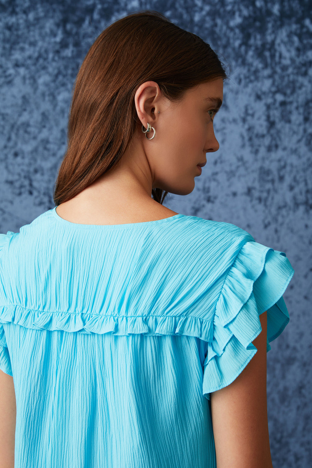 Solid blue shirt with a straight silhouette and a v-neck neckline 