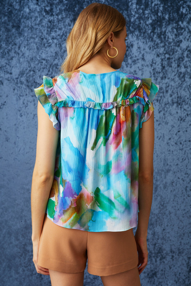 Short sleeve shirt with a blue multicolor print, two tiered ruffle sleeves, and ruffles going across the chest