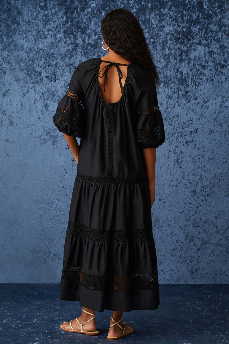 Long dress with a rounded neckline and a scoop back with a tie at the top of the back in a solid black color
