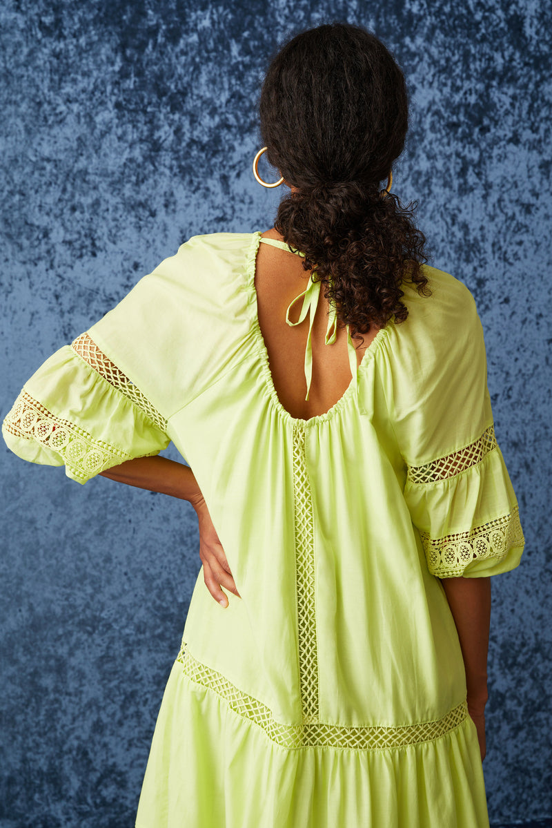 Long dress with a rounded neckline and a scoop back with a tie at the top of the back in a solid bright green color