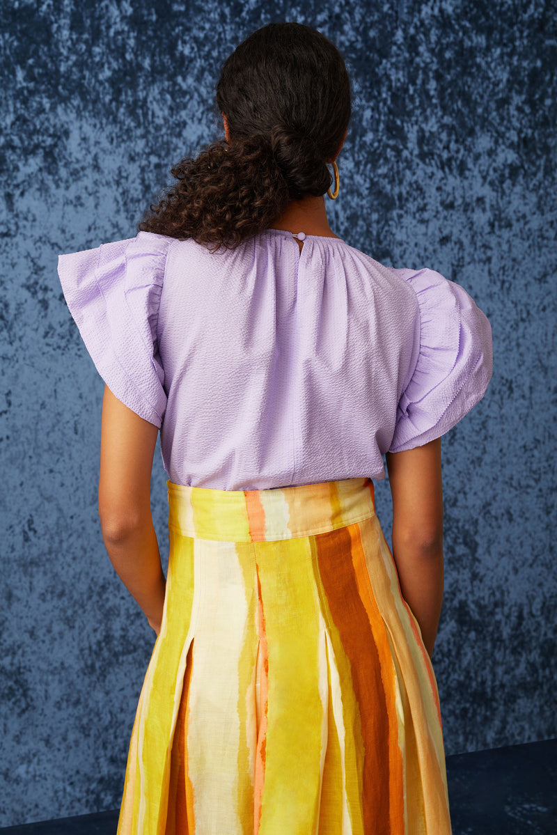 Light purple top with a rounded neckline and button closure at the back of the neck