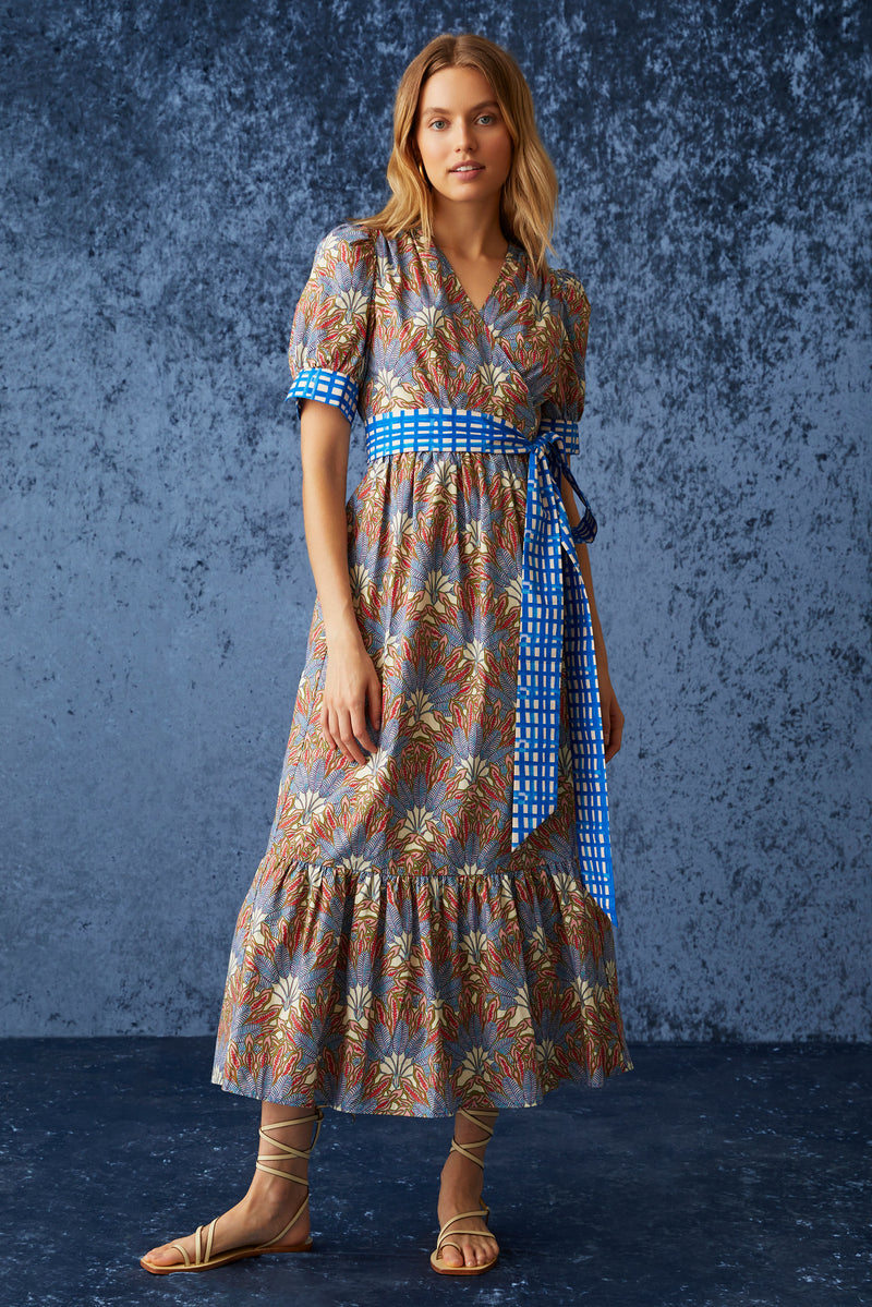 Maxi dress in a blue and red floral print with a blue and white checkered belt at the waist