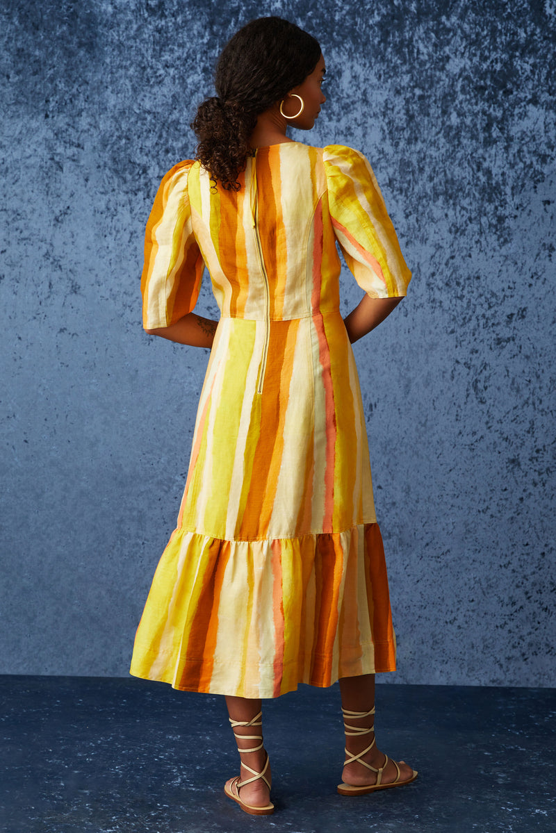 Orange and yellow printed midi dress that has a square neckline and is cinched at the waist 