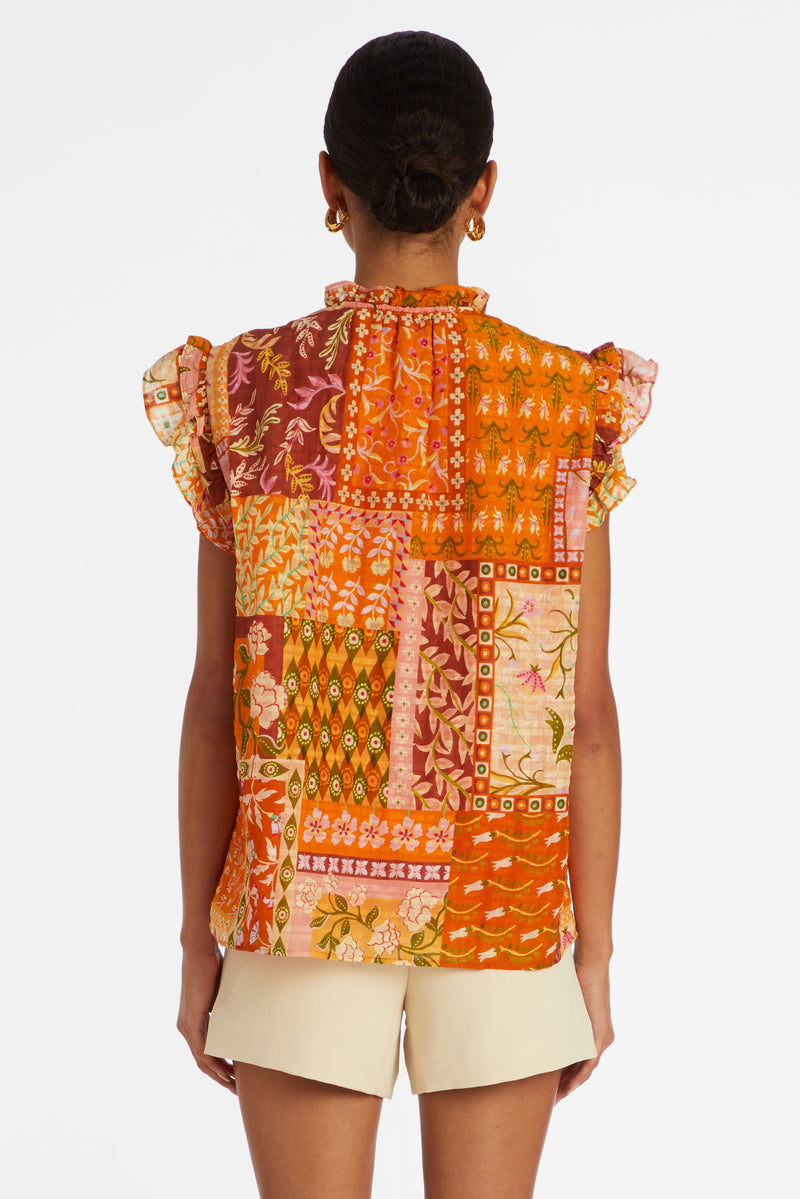 Short flutter sleeve top with a straight silhouette in a floral patchwork orange print