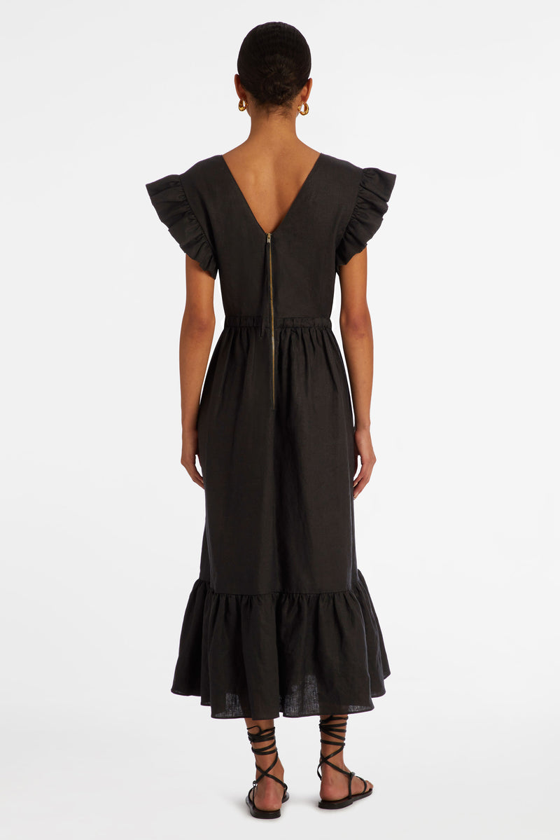Long dress in a solid black with ruffle at the shoulder and v-neckline in the front and back of the dress