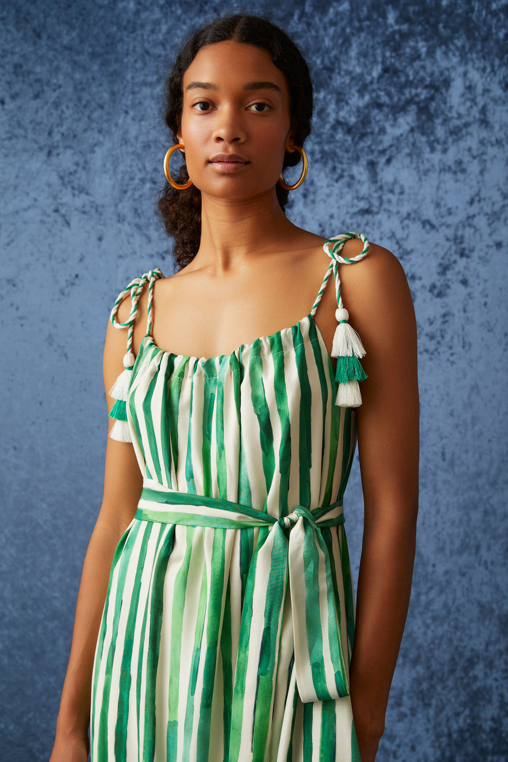 Maxi dress in a green and white vertical striped pattern with adjustable ties at the shoulder